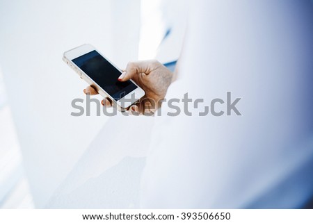 Closeup image of a businesswoman is searching information in network on mobile phone during free time. Young female student is revising photos on her cell telephone during break between lectures