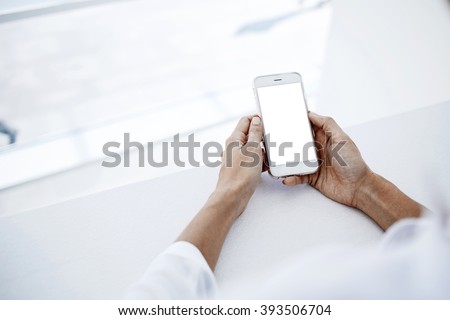 Closeup image of woman`s hands is holding smart phone with blank copy space screen for your advertising text message or promotional content.Female is searching information in network on cell telephone