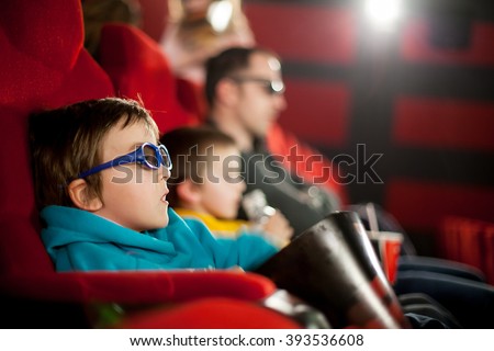 Father and two children, boys, watching cartoon movie in the cinema on 3D 