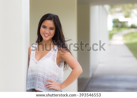 Portrait of a smiling young pretty Asian girl with long brown hair