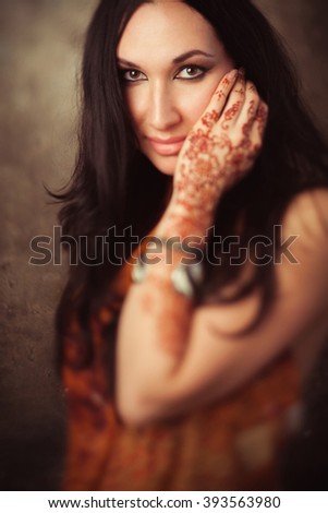 Tender indian woman in traditional clothing with mehndi on hand. Playful indian girl in  sari with mehndi. Beautiful lady in indian dress