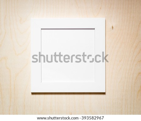 Empty white wooden photo frame hanging on wooden wall