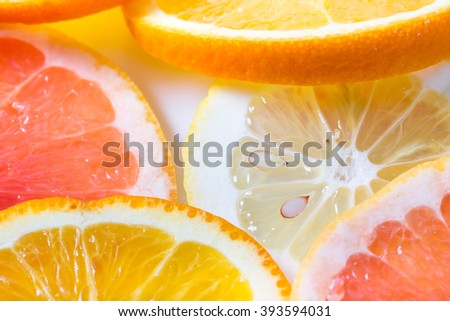 The citrus cut by circles lies on a table. Orange, lemon, grapefruit. Close up, small depth of sharpness