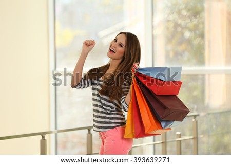 Young pretty woman with shopping packages  in the shop