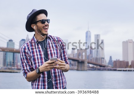 Man listening music with his smartphone in Brooklyn, New York Royalty-Free Stock Photo #393698488