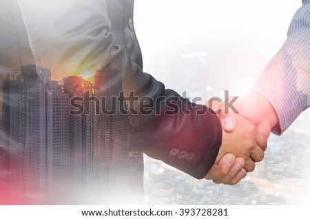 Double exposure of businessman handshake and city.