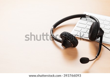 Office desk with headset and pc. Call center support table. Veiw with copy space Royalty-Free Stock Photo #393766093