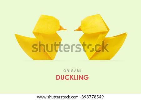Origami paper yellow ducklings pair floating on a mint green background