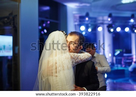 Beautiful happy newlyweds hugging on wedding celebration