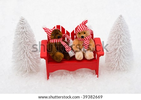 White evergreen trees sitting with teddy bears on snow with a snow background, winter bears