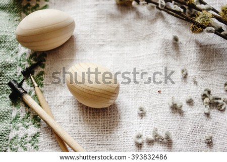 simple wooden easter eggs and willow buds and wax sticks on rustic napkin with embroidery