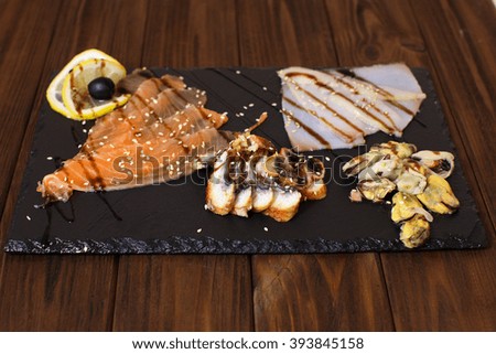 Delicious smoked salmon fish platter garnished with lemon and red caviar. Isolated on a white background.
