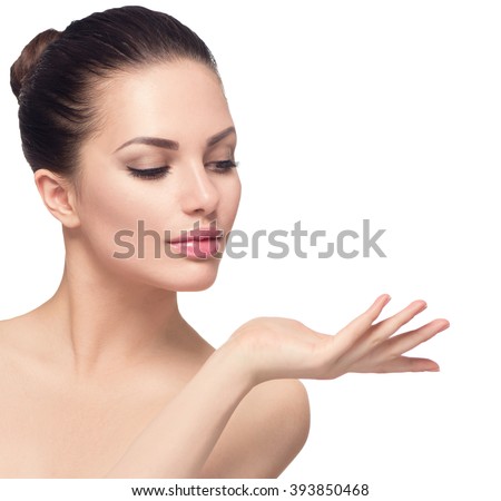 Beauty Spa Woman with perfect face skin Portrait. Beautiful Brunette Spa Girl showing empty copy space on the open hand palm for text. Proposing a product. Gesture for advertisement. Isolated on white
