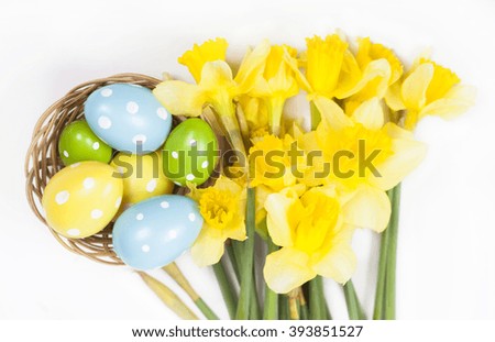 Easter background with colorful Easter eggs and a bouquet of yellow daffodils