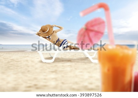 blurred background of beach and orange juice with slim woman on chair 