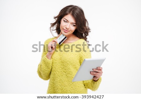 Happy woman holding credit card and using tablet computer isolated on a white background