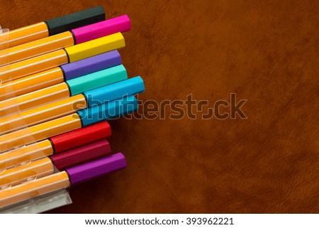 various color multicolor pen on leather background Royalty-Free Stock Photo #393962221