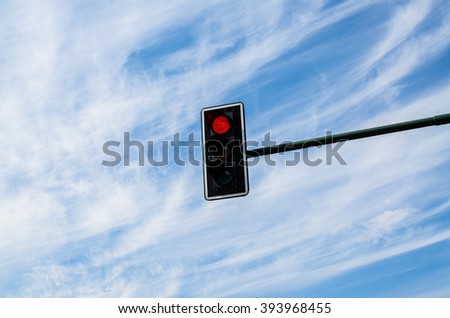 Traffic lights against cloudy blue sky