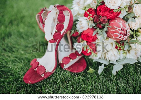 Wedding. The bride's bouquet. Wedding bouquet . A bouquet of red, white flowers and greenery, lies on the grass