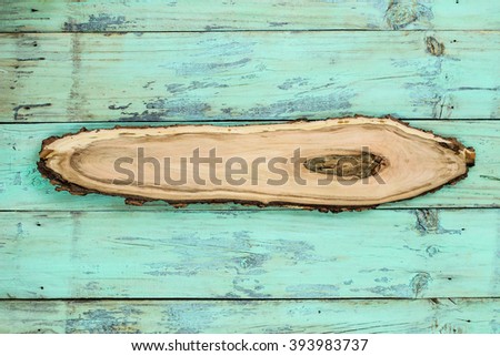 Blank rustic wooden sign with knot hanging on washed out mint green distressed wood background