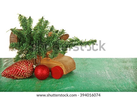 Wooden toy car with Christmas tree and toys on a table over white background