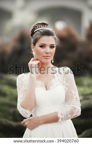 Wonderful bride with a luxurious white dress posing in the old town