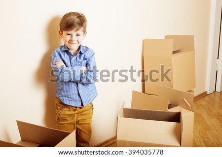 little cute boy in empty room, remoove to new house. home alone emong boxes