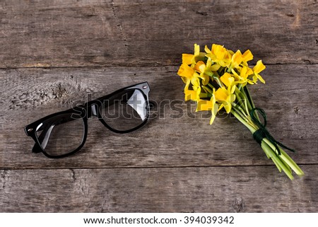 Yellow daffodils and glasses on the table.