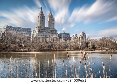 High rise buildings around Central Park with blurry foreground and moving clouds