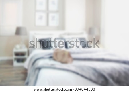 Blurred bedroom with white and grey bed