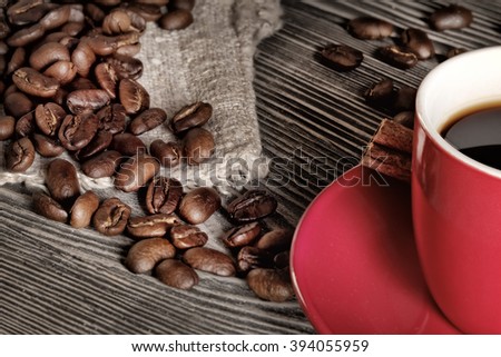 Detail cup of coffee and beans on wooden table