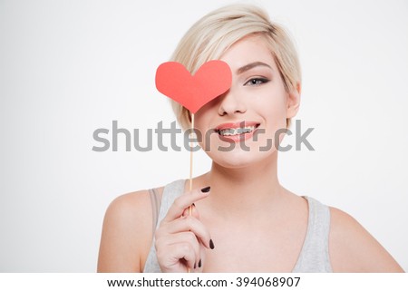 Smiling woman holding red heart isolated on a white background