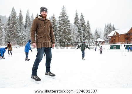 Portrait of a happy man ice skating outdoors
