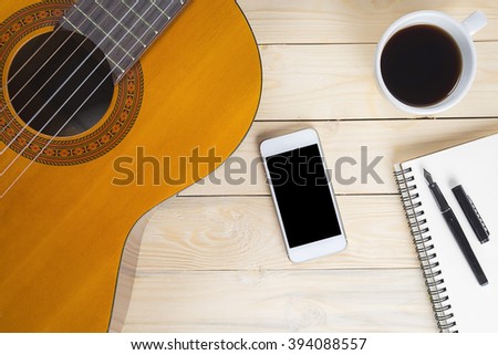 classical guitar on a wooden table.cup of coffee for the music composer,vintage effect.
