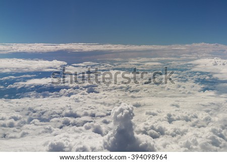 View of the  sky and fluffly clouds from the airplane porthole