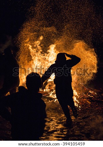 An young man is participating in a fire ritual during a celebration of Sirni Zagovezni. It is believed that evil spirits are chased away with this fire rituals.