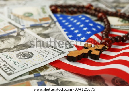 American flag with dollars and rosary beads, closeup