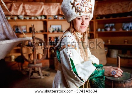 Young woman in traditional yurt dwelling. Royalty-Free Stock Photo #394143634