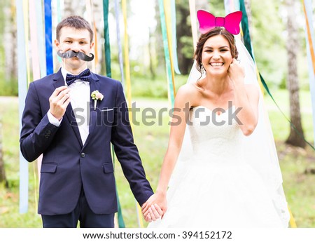 April Fools' Day. Wedding couple posing with mask. Royalty-Free Stock Photo #394152172