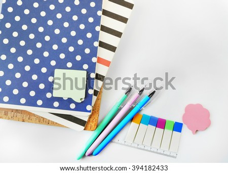 A pile of stylish notebooks and stationary, isolated on white background