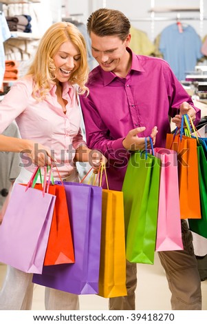 Image of woman showing to man what she bought in the shop