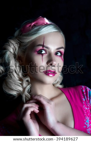 Beautiful blonde girl with two pigtails, with creative make-up: pink glossy lips, wearing pink skeleton dress. for the Halloween party. Close up