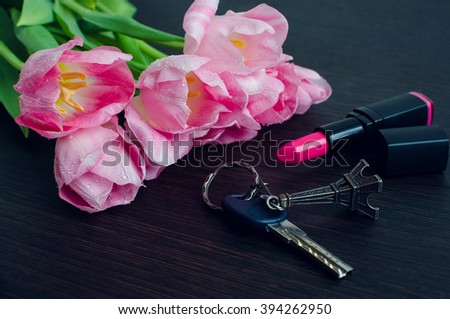 Tulips with lipstick on dark wooden background and key with Eiffel Tower. Spring flowers. March 8th, mother's day, valentine's day, International Women's Day, congratulate.  Toned image. 