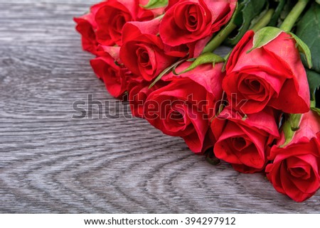 Red roses on a grey wooden background