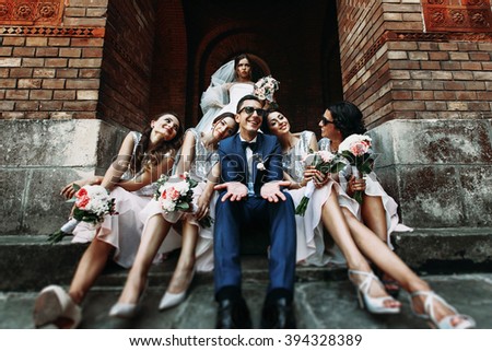 Handsome groom posing with fun beautiful bridesmaids