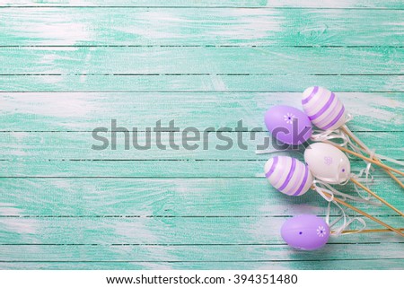 Easter/spring background. Decorative violet eggs on turquoise  wooden background. Selective focus. Place for text.