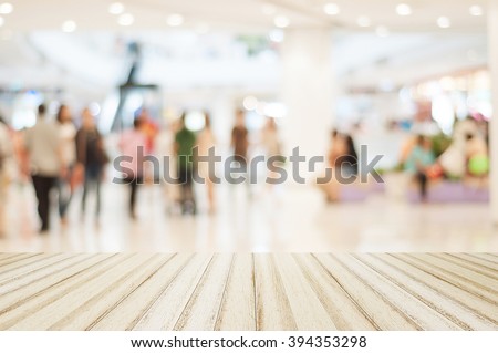 Wood floor with blurred people in shopping mall for background