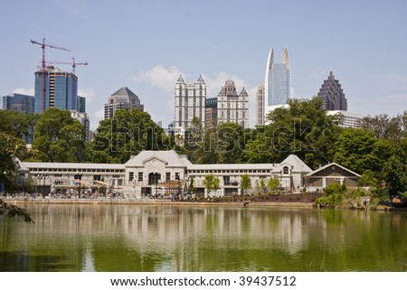A view of the Atlanta Skyline shot from Piedmont Park with public pool behind lake