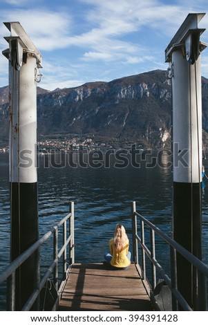 girl sitting on a pier of Lake Como