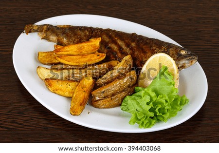 Grilled trout with potato, salad leaves and lemon